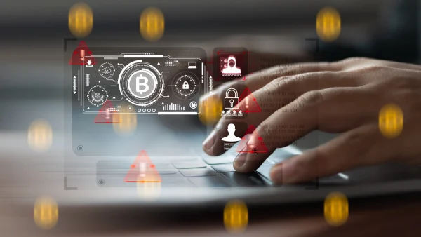 A person typing on a laptop with digital Bitcoin and security warning symbols, illustrating crypto KYC challenges like fraud, ransomware, and regulatory risk
