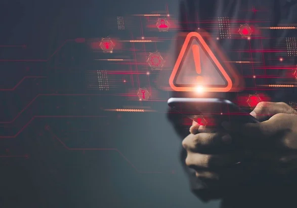 Conceptual image of a person holding a smartphone with digital warning symbols, representing corporate security trends in mobile threat detection and real-time alerting