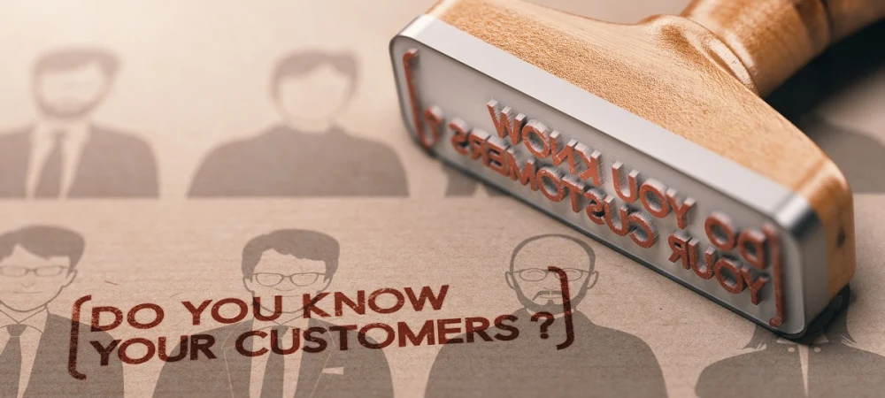 A rubber stamp marking the words “Do you know your customers?” onto paper, symbolizing the KYC onboarding process