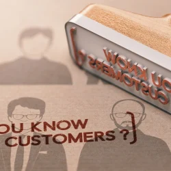 A rubber stamp marking the words “Do you know your customers?” onto paper, symbolizing the KYC onboarding process