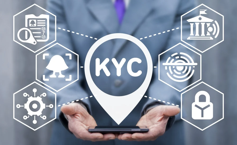 Businessperson holding a smartphone with floating digital icons representing KYC processes such as identity verification and financial information checks