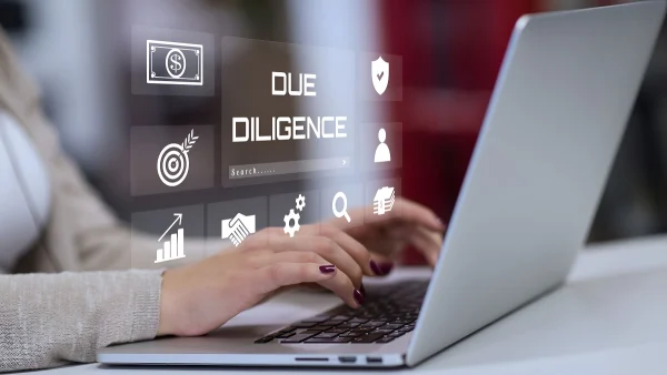 Person using a laptop with digital icons symbolizing customer risk assessment and compliance processes in KYC and CDD