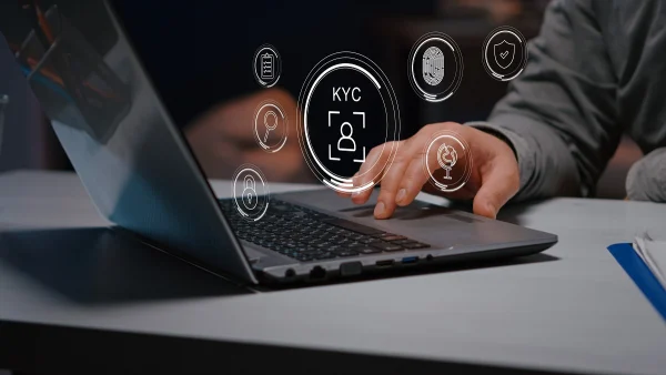 Person using a laptop surrounded by virtual KYC icons, representing online identity verification and secure onboarding in banking