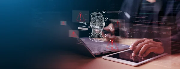 Cybersecurity concept showing a person using a laptop and tablet with a digital wireframe face, warning icons, and deepfake alerts symbolizing AI-driven fraud detection tools